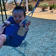 Saint joined the competition — help win amazing prizes! child, toddler, swing, playground, outdoor, smiling, blue_swing, trees, sunny, daytime, grass, residential_area, person, happy, holding, play, recreation, casual_clothing, fun, park