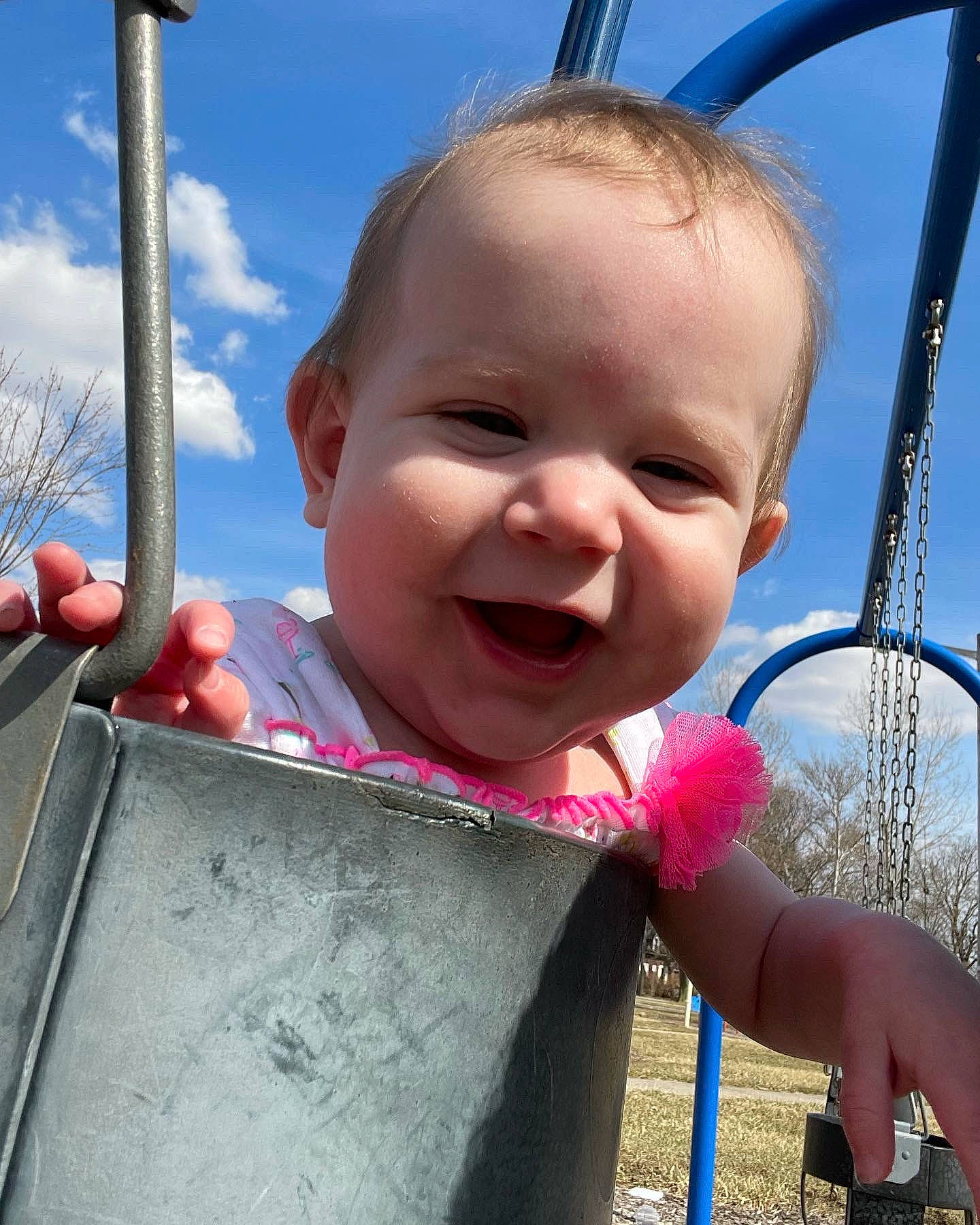 Mallory is registered to the contest to win money with this photo: baby_toddler_clothing, blue, cheek, chin, cloud, eye, facial_expression, gesture, happy, iris, leisure, mouth, nose, person, pink, skin, sky, smile, standing, thumb