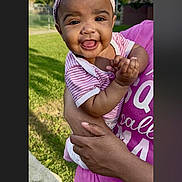 Veronica-Faith is registered to the contest to win money with this photo: baby, child, smiling, headband, pink, striped_shirt, adult_hand, outdoor, greenery, grass, person, portrait, happy, holding, closeup, cute, infant, daylight, nature, casual_clothing