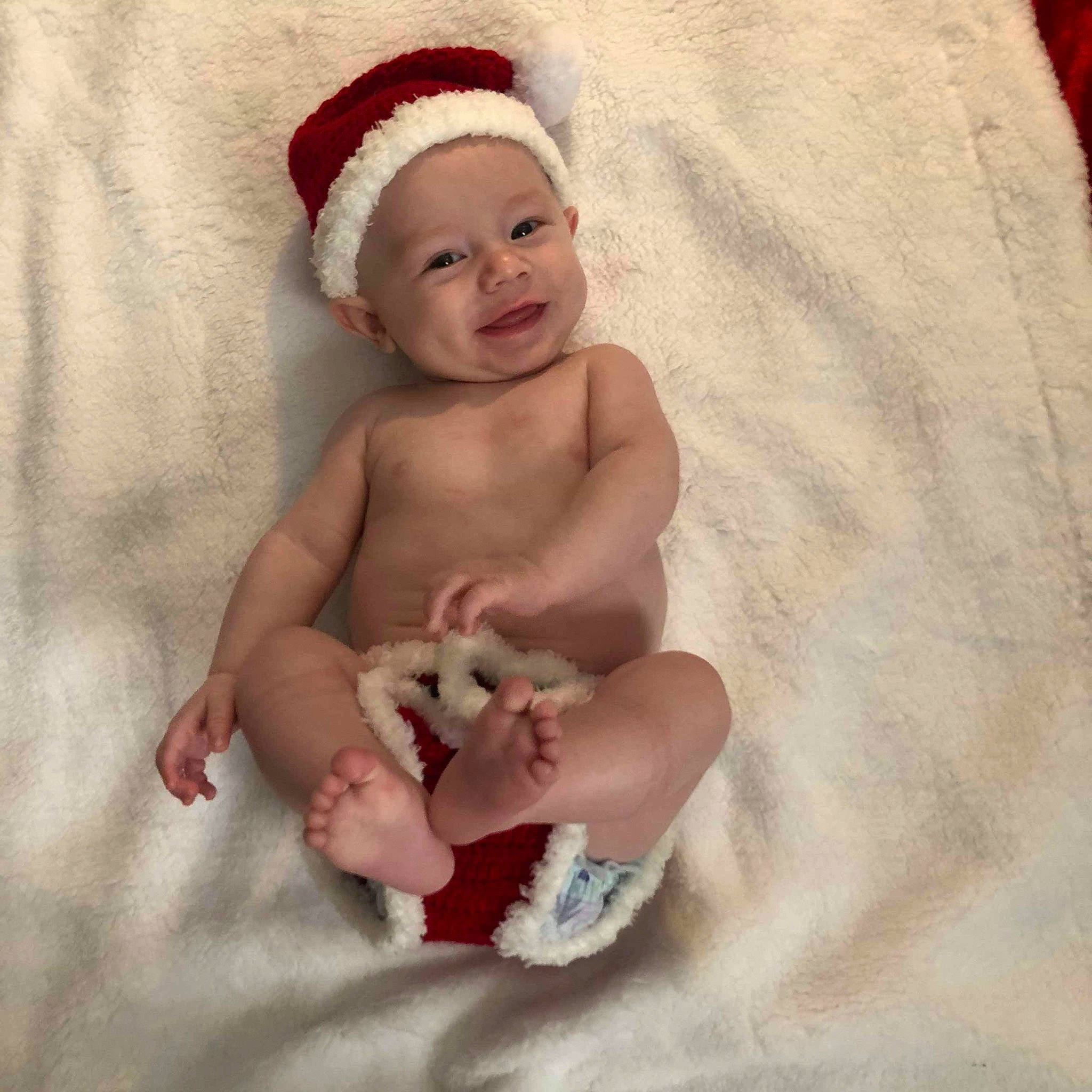 Rick is registered to the contest to win money with this photo: baby, baby_sleeping, beanie, bonnet, cap, child, fictional_character, finger, hand, head, headgear, headwear, knit_cap, leg, person, photography, skin, smile, stomach, toddler