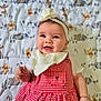 adorable, animal_print, baby, blanket, checkered_pattern, child, clothing, cute, face, flower, hand, happy, headband, indoors, infant, lying_down, portrait, red_dress, smiling, young_child