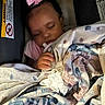 Loyalty is registered to the contest to win money with this photo: baby, infant, sleeping, pacifier, pink_bow, curly_hair, blanket, floral_blanket, car_seat, vehicle_interior, portrait, close_up, cozy, snuggled, hand, soft_lighting, child, face, resting, safe