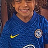 Imran participe au concours pour gagner de l'argent avec cette photo : child, smiling, curly_hair, blue_jersey, chelsea, soccer_shirt, happy, portrait, person, sportswear, casual, standing, indoor, young, cute, team_logo, nike, childhood, friendly, closeup