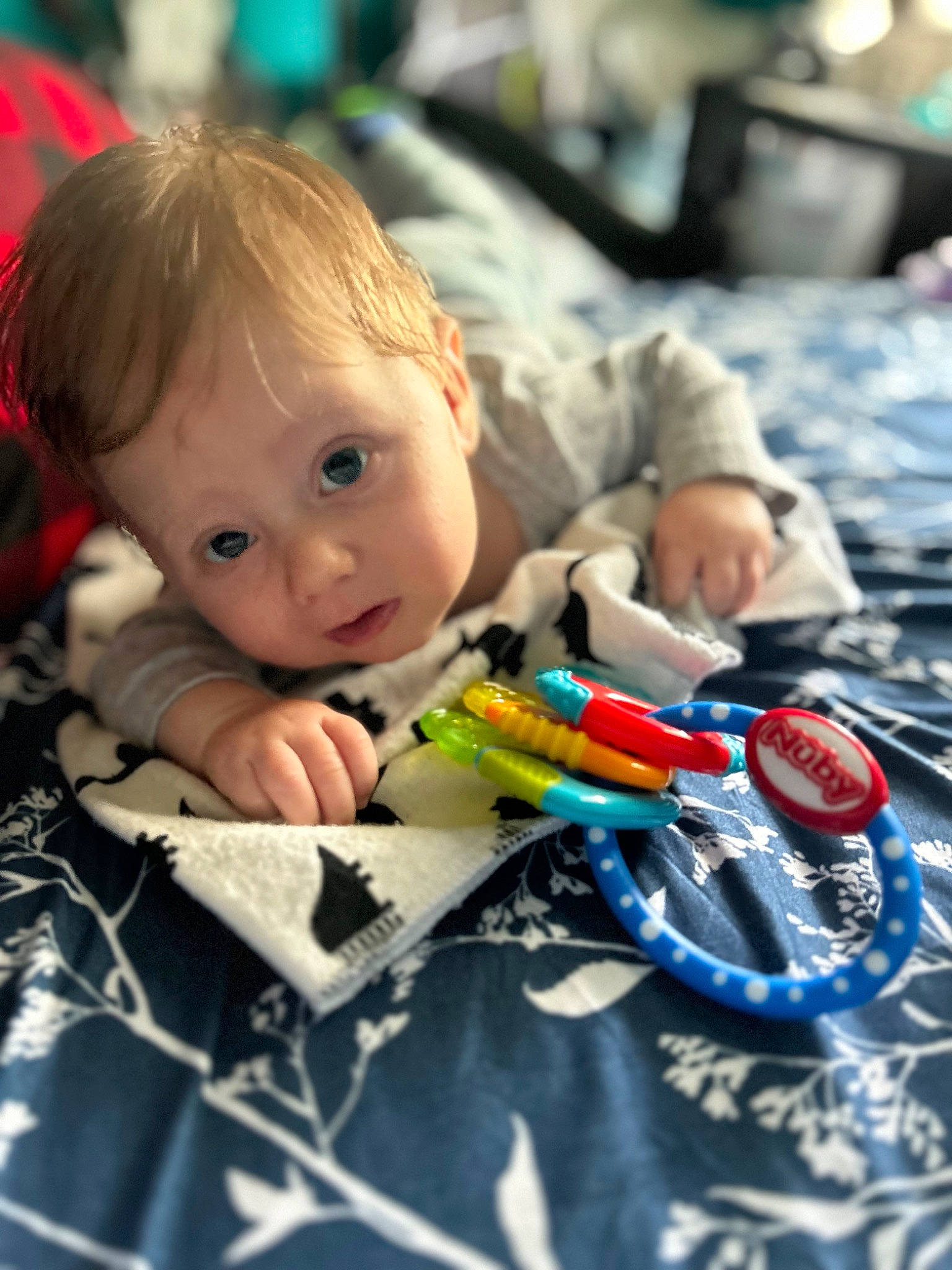 Hayden is registered to the contest to win money with this photo: baby, baby_products, cheek, child, fun, happy, iris, leisure, person, plastic, play, room, sitting, smile, surprise, t_shirt, toddler, toy, toy_vehicle, visual_arts