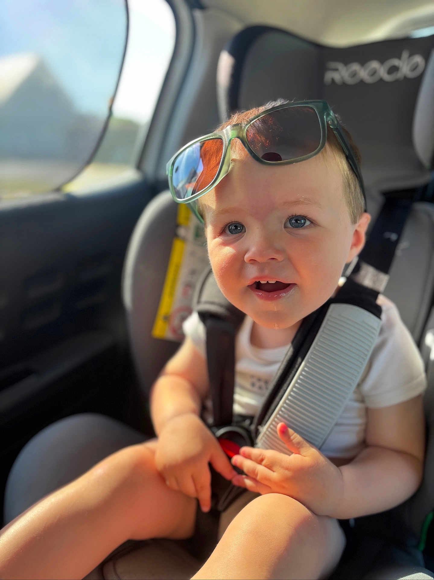 Jules participe au concours pour gagner de l'argent avec cette photo : toddler, child, car_seat, sunglasses, sunlight, blue_eyes, seatbelt, car_interior, happy, cute, baby, sitting, casual_clothing, closeup, daylight, portrait, infant, safety_harness, young_child, smiling