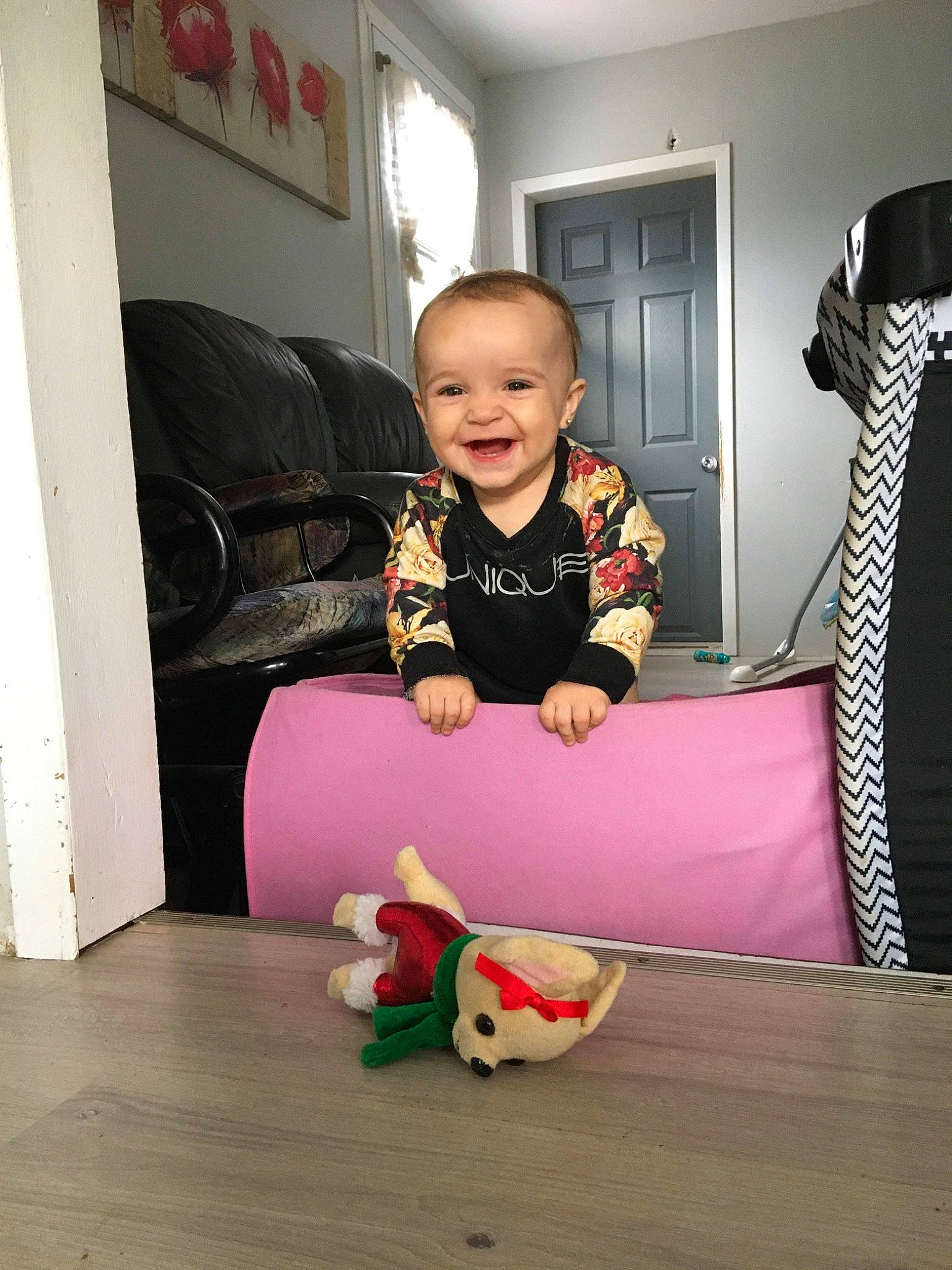 Malia is registered to the contest to win money with this photo: baby, baby_toddler_clothing, child, comfort, couch, floor, flooring, fun, happy, hardwood, house, joy, living_room, mammal, person, picture_frame, room, sitting, smile, sock