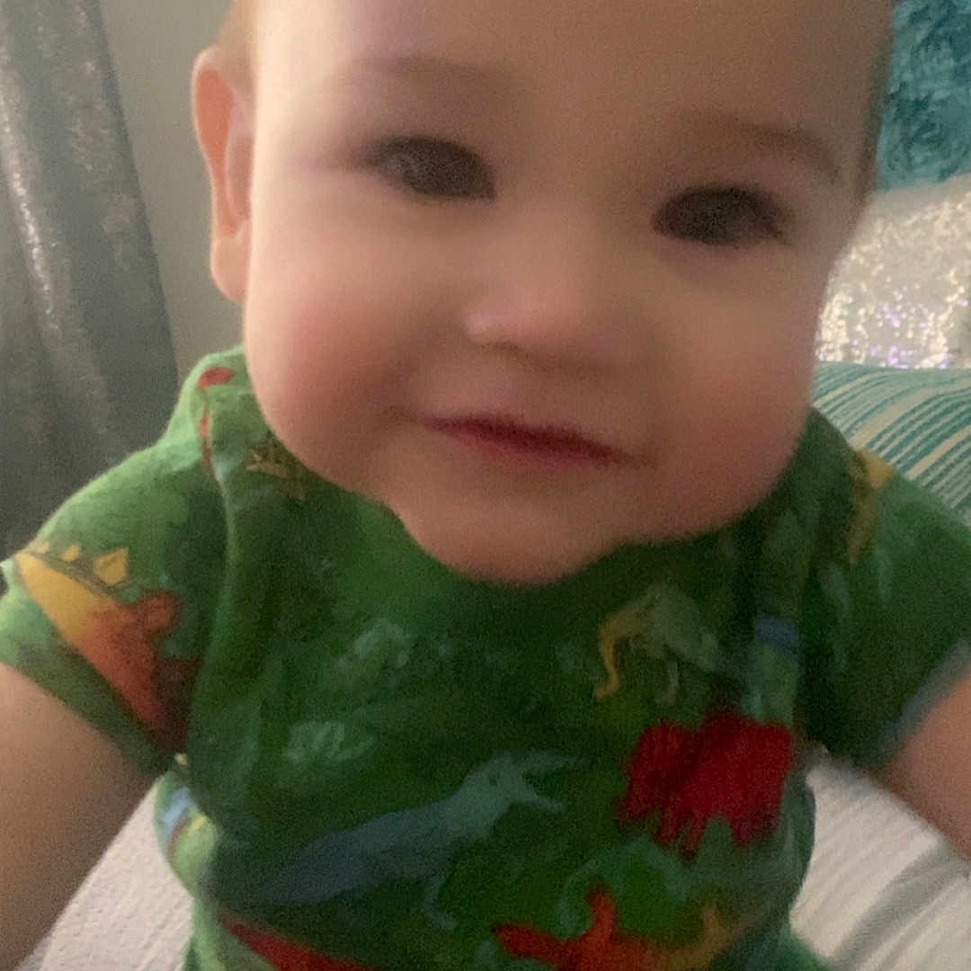 Zyro Duran is registered to the contest to win money with this photo: baby, bodypart, clothing, cushion, dress, face, happy, head, homedecor, indoors, mouth, pajamas, person, photography, portrait, selfie, shirt, smile, t_shirt, teeth