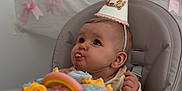 Novella is registered to the contest to win money with this photo: baby, birthday_cake, high_chair, party_hat, pink_bows, frosting, rainbow_cake, celebration, child, cake, pastel_colors, cute, happy, indoor, food, dessert, face, smile, person, event