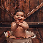 Aaron a rejoint le concours — aidez-le/la à gagner de superbes lots ! baby, bare_chest, bath, bucket, child, citrus, grapefruit, happy, indoor, laughing, orange_slices, playful, portrait, rustic, smiling, toddler, tub, water, wooden_background, wooden_floor