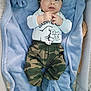 Bastien participe au concours pour gagner de l'argent avec cette photo : baby, blue_blanket, camo_pants, child, clothing, cozy, crib, cute, face, hands, hat, headwear, indoor, infant, looking_up, lying_down, playpen, smiling, soft_texture, white_long_sleeve