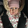 baby, blue_eyes, car_seat, child, clothing, cute, face, floral_pattern, fur_trim, hands, indoors, infant, pink_hat, pom_poms, portrait, safety_harness, seat, straps, warm_clothing, winter_jacket