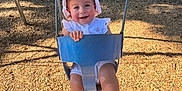 Bayley joined the competition — help win amazing prizes! toddler, child, swing, playground, sunhat, summer, smile, outdoor, grass, woodchips, sunlight, happy, footwear, sandals, clothing, park, trees, daylight, person, seat