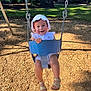 toddler, child, swing, playground, sunhat, summer, smile, outdoor, grass, woodchips, sunlight, happy, footwear, sandals, clothing, park, trees, daylight, person, seat
