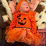 Oakley is registered to the contest to win money with this photo: baby, infant, sleeping, halloween, pumpkin, costume, orange, headband, bow, tutu, dress, blanket, plush, portrait, face, indoors, cozy, couch, cute, family