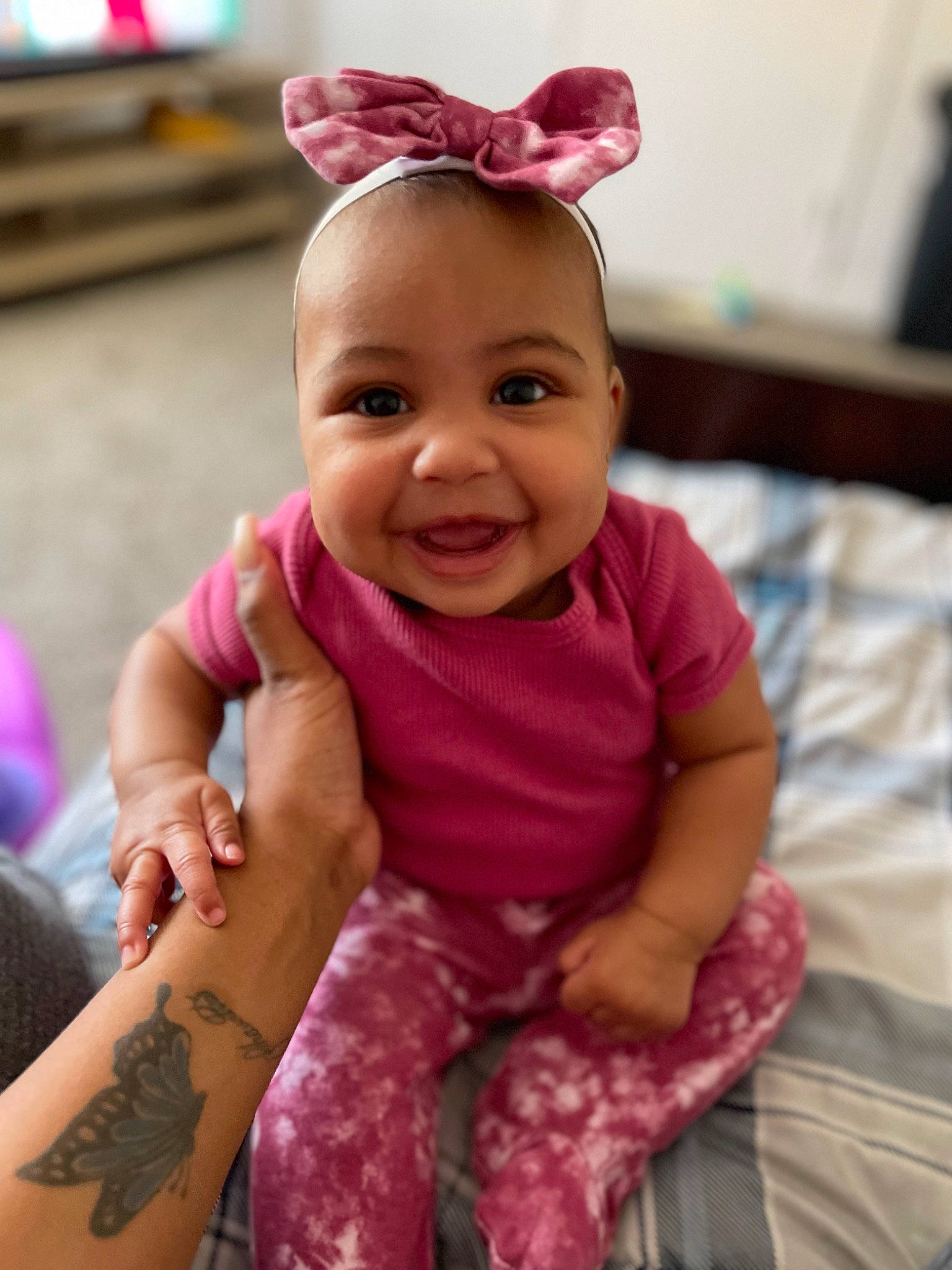 Kyori is registered to the contest to win money with this photo: baby, baby_toddler_clothing, child, face, fashion_accessory, finger, fun, gesture, happy, joy, magenta, neck, pattern, person, pink, purple, skin, sleeve, smile, textile