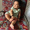baby, child, sitting, chair, patterned_fabric, colorful, curly_hair, indoors, footwear_none, bracelet, mint_green, pink_leggings, expression_curious, metal_frame, floor, person, portrait, casual_clothing, cute, comfort