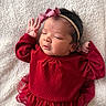 baby, newborn, infant, red_dress, headband, bow, sleeping, face, hand, blanket, soft_texture, cute, portrait, child, young, peaceful, indoors, skin, person, toddler