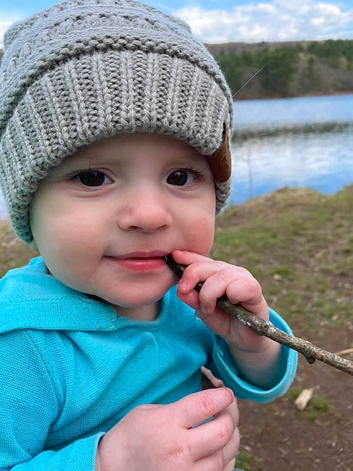 Mac is registered to the contest to win money with this photo: baby, baby_toddler_clothing, blue, cap, cheek, child, cloud, eye, face, gesture, grass, hand, headwear, knit_cap, lake, lip, nose, person, skin, sky