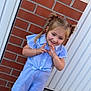 Eloïse participe au concours pour gagner de l'argent avec cette photo : child, girl, pigtails, smile, blue_clothing, striped_outfit, sandals, brick_wall, door, sidewalk, playful, outdoor, person, young_child, cute, happy, posing, fashion, summer, casual