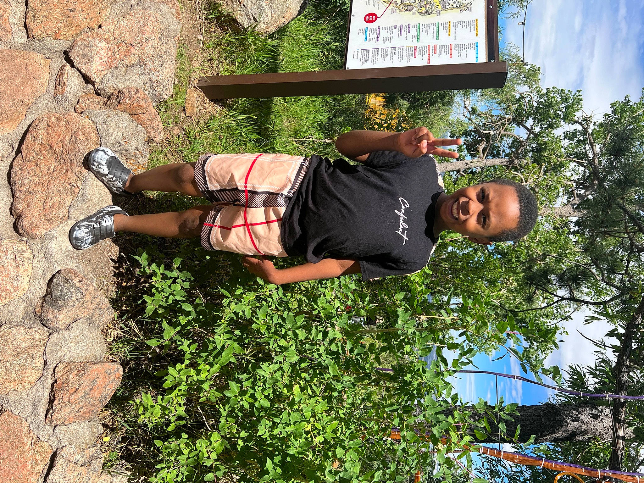Jayden is registered to the contest to win money with this photo: adventure, fun, grass, landscape, leaf, leisure, people_in_nature, person, plant, recreation, shorts, shrub, sky, t_shirt, thigh, travel, tree, vacation, walking_shoe