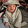 Maycie joined the competition — help win amazing prizes! baby, child, hood, robe, blanket, couch, smile, face, clothing, soft, indoors, cute, comfort, warm, infant, person, sitting, happy, plush, cozy