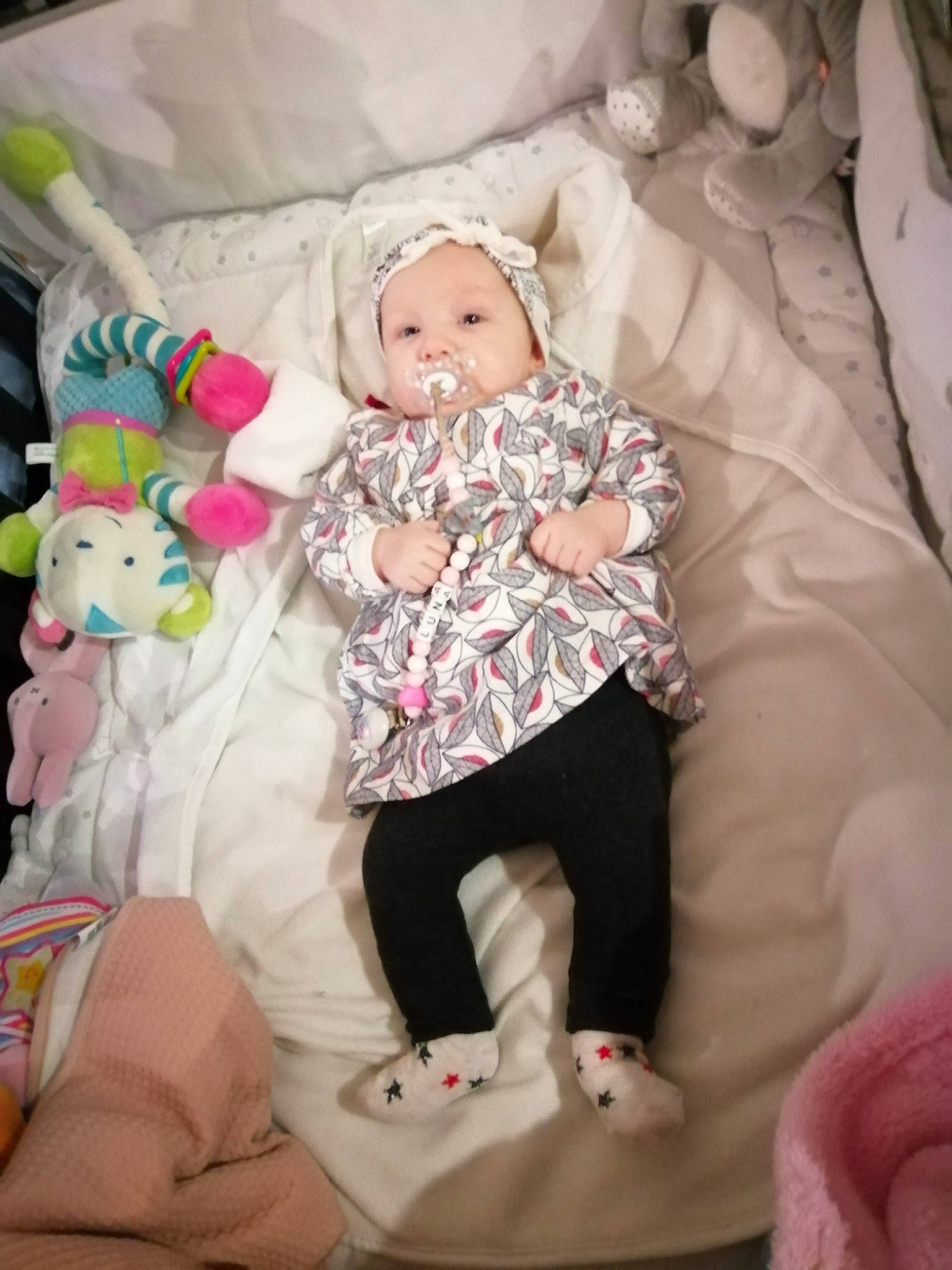 Luna participe au concours pour gagner de l'argent avec cette photo : baby, baby_products, baby_toddler_clothing, cheek, child, comfort, fun, headwear, human_leg, lap, linens, magenta, pattern, person, pink, room, sitting, skin, sleeve, sock