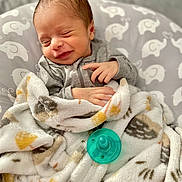 Morgan joined the competition — help win amazing prizes! baby, bed, blanket, clothing, cozy, cute, face, gray, hand, infant, nap, newborn, pacifier, pattern, peaceful, sleeping, smiling, soft, wrapped, yellow