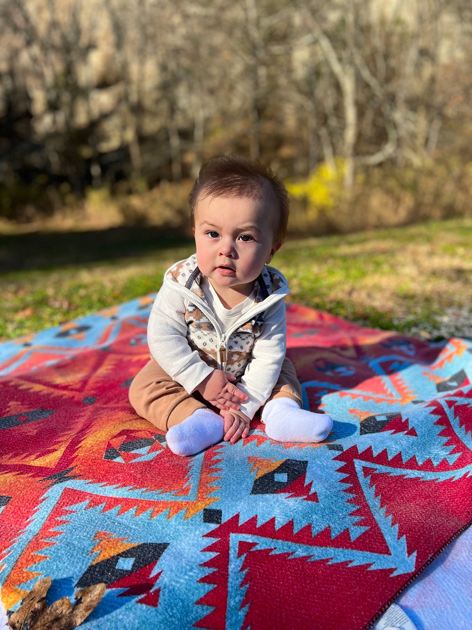 Forrest is registered to the contest to win money with this photo: baby, baby_toddler_clothing, eye, flooring, grass, happy, head, leisure, linens, people_in_nature, person, plaid, plant, red, sunlight, tartan, tints_and_shades, toddler, tree, wood