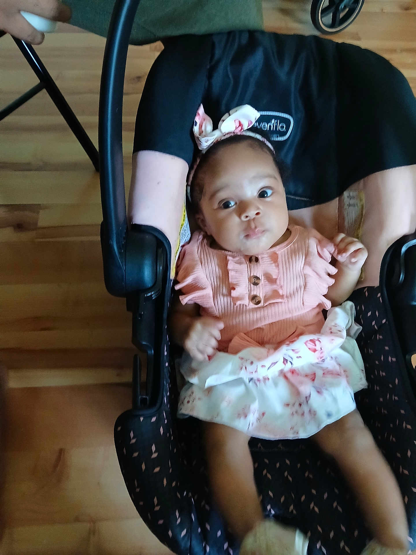 Lilah Perry joined the competition — help win amazing prizes! baby, infant, car_seat, pink_dress, headband, floral_pattern, wooden_floor, baby_clothing, child, person, indoor, hand, footwear, seat, cute, portrait, young_child, baby_girl, looking, sitting