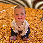 Callum is registered to the contest to win money with this photo: baby, child, corn, grain, silo, smiling, happy, sitting, clothing, barefoot, face, portrait, indoor, rustic, yellow, metal, texture, cute, infant, playful