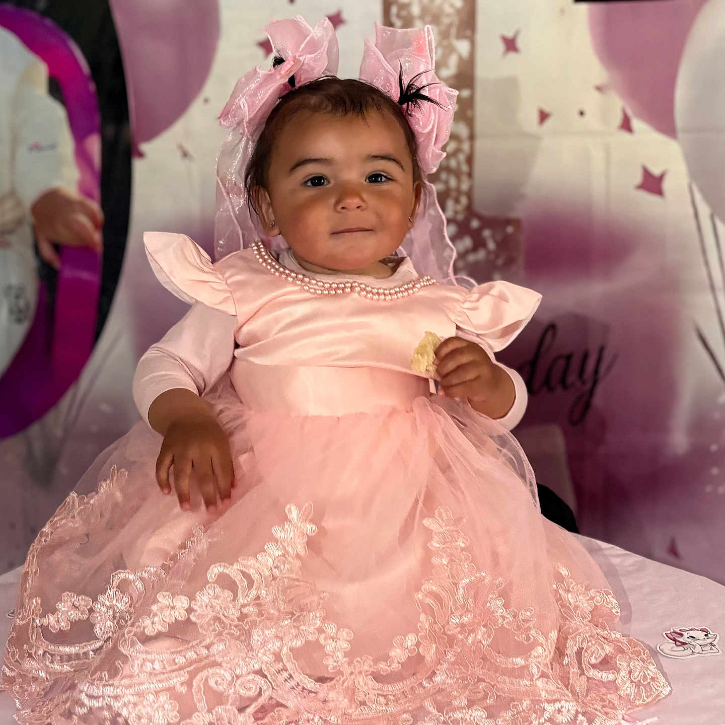 Esmée a rejoint le concours — aidez-le/la à gagner de superbes lots ! toddler, baby, girl, pink_dress, lace, bows, birthday, party, celebration, table, balloons, decorations, child, portrait, smiling, cute, indoors, person, food, festive