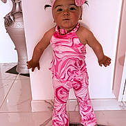 Esmée a rejoint le concours — aidez-le/la à gagner de superbes lots ! toddler, child, pink_clothing, headband, bow, standing, marble_floor, vase, decor, pigtails, barefoot, wall, indoor, portrait, cute, fashion, playful, expression, person, floor