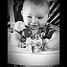 baby, child, smile, face, toy, walker, infant, hands, play, happy, monochrome, black_and_white, closeup, young, person, candid, indoors, cute, expression, seated