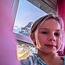 blonde_hair, blue_clothing, child, closeup, curtains, daylight, face, girl, headshot, home, indoors, photography, pink, portrait, red, ruffled_collar, selfie, smile, sunlight, window