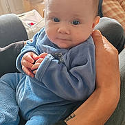 Rose a rejoint le concours — aidez-le/la à gagner de superbes lots ! baby, child, infant, blue_clothing, hands, face, person, indoor, soft_lighting, seated, adult_hand, tattoo, pajamas, window, curious_expression, portrait, cozy, home, couch, casual