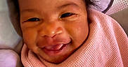 Divinity is registered to the contest to win money with this photo: baby, blanket, child, closeup, cozy, cute, expression, face, hair, happy, indoors, infant, pillow, pink, skin, smile, soft, tongue, warm, wrapped