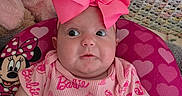 Amiracle is registered to the contest to win money with this photo: baby, barbie_outfit, child, childrens_room, closeup, crocheted_blanket, curious_expression, cute, headwear, heart_pattern, indoors, infant, mickey_mouse_cushion, patterned_clothing, pink, pink_bow, plush_toy, portrait, seated, soft_texture
