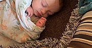 Emma is registered to the contest to win money with this photo: baby, newborn, sleeping, blanket, crochet, cushion, patterned, striped, floral, cozy, indoors, rest, peaceful, wrapped, soft, face, person, child, homedecor, comfort