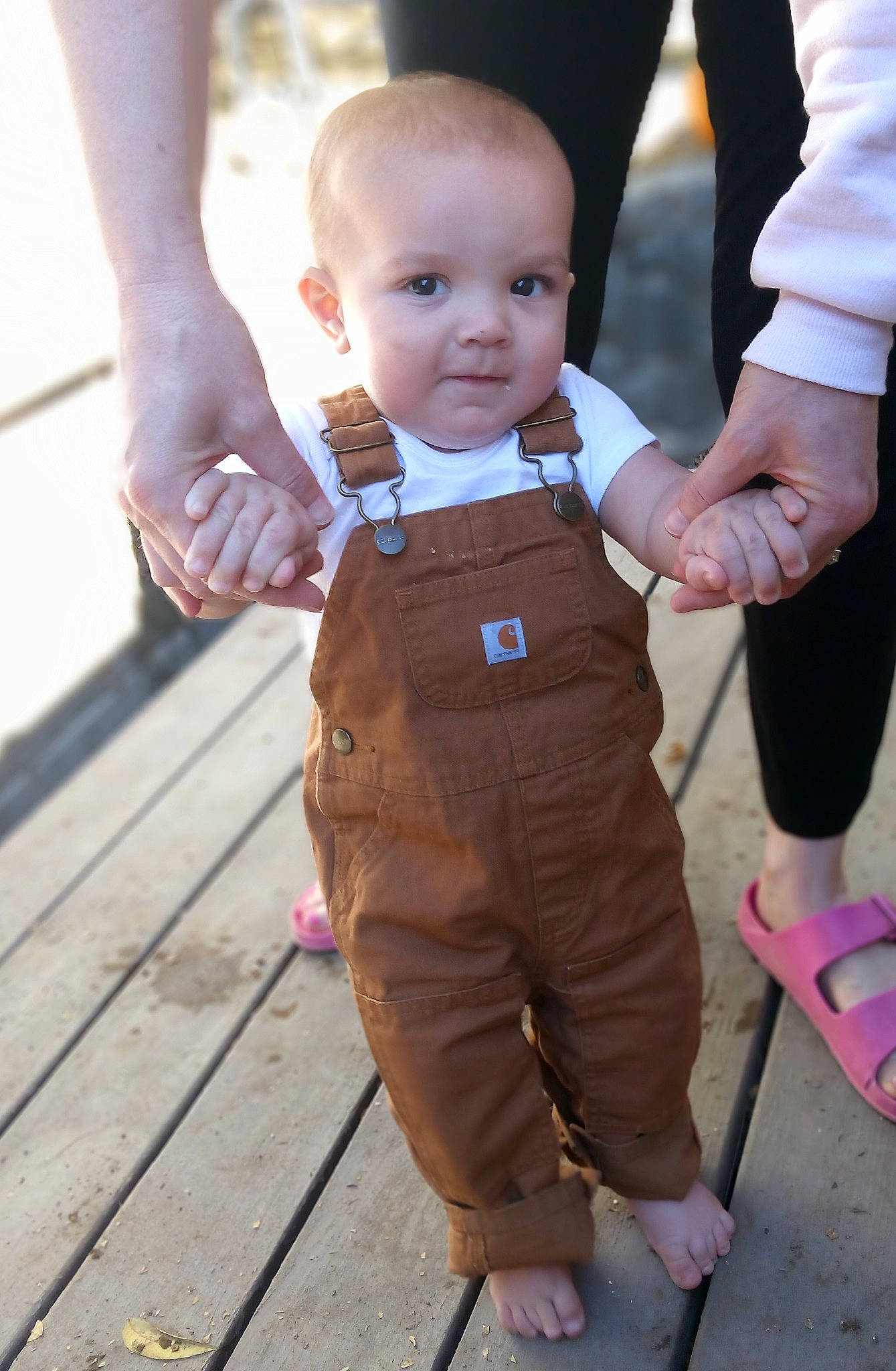 Antonio is registered to the contest to win money with this photo: baby, baby_toddler_clothing, belt, child, event, formal_wear, fun, gesture, happy, holding_hands, leisure, people_in_nature, person, sleeve, standing, thumb, toddler, vacation, wood
