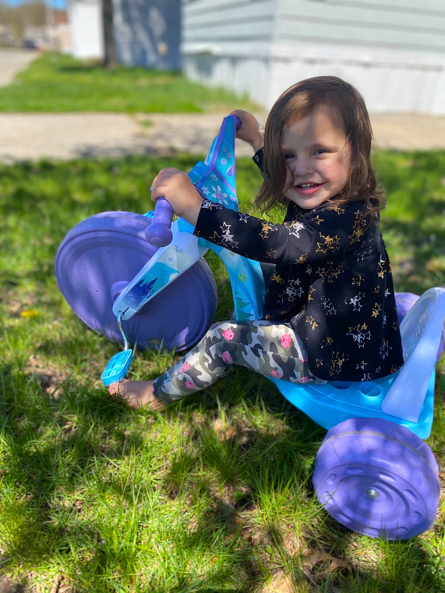 Emilee is registered to the contest to win money with this photo: blue, child, costume, fun, grass, joy, lawn, liquid_bubble, person, plant, play, purple, sitting, smile, spring, toddler, vacation