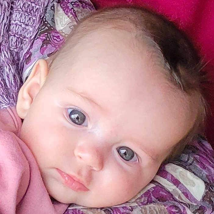 Jade participe au concours pour gagner de l'argent avec cette photo : baby, infant, face, eyes, blanket, pink_clothing, head, skin, portrait, closeup, child, young, lying_down, soft_texture, curious, innocent, expression, human, person, indoors