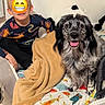 child, dog, bed, blanket, smile, indoor, animal_print, black_and_white_dog, happy, person, toy, furniture, cute, young, cozy, colorful, pet, room, sitting