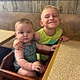 Parker is registered to the contest to win money with this photo: arm_around, baby, booth, boy, child, clothing, cute, diner, expression, family, furniture, hand, happy, indoor, portrait, seat, smile, table, toddler, wood_paneling