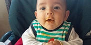 Nino participe au concours pour gagner de l'argent avec cette photo : baby, high_chair, bib, food_stains, indoor, child, face, hands, curious, seated, clothing, feeding, cute, infant, table, person, portrait, expression, young_child, seat