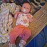 baby, blanket, carpet, child, clothing, comfort, cute, floral, footwear, indoor, infant, lying_down, pacifier, person, pink_pants, resting, shoes, soft_blanket, toddler, young_child