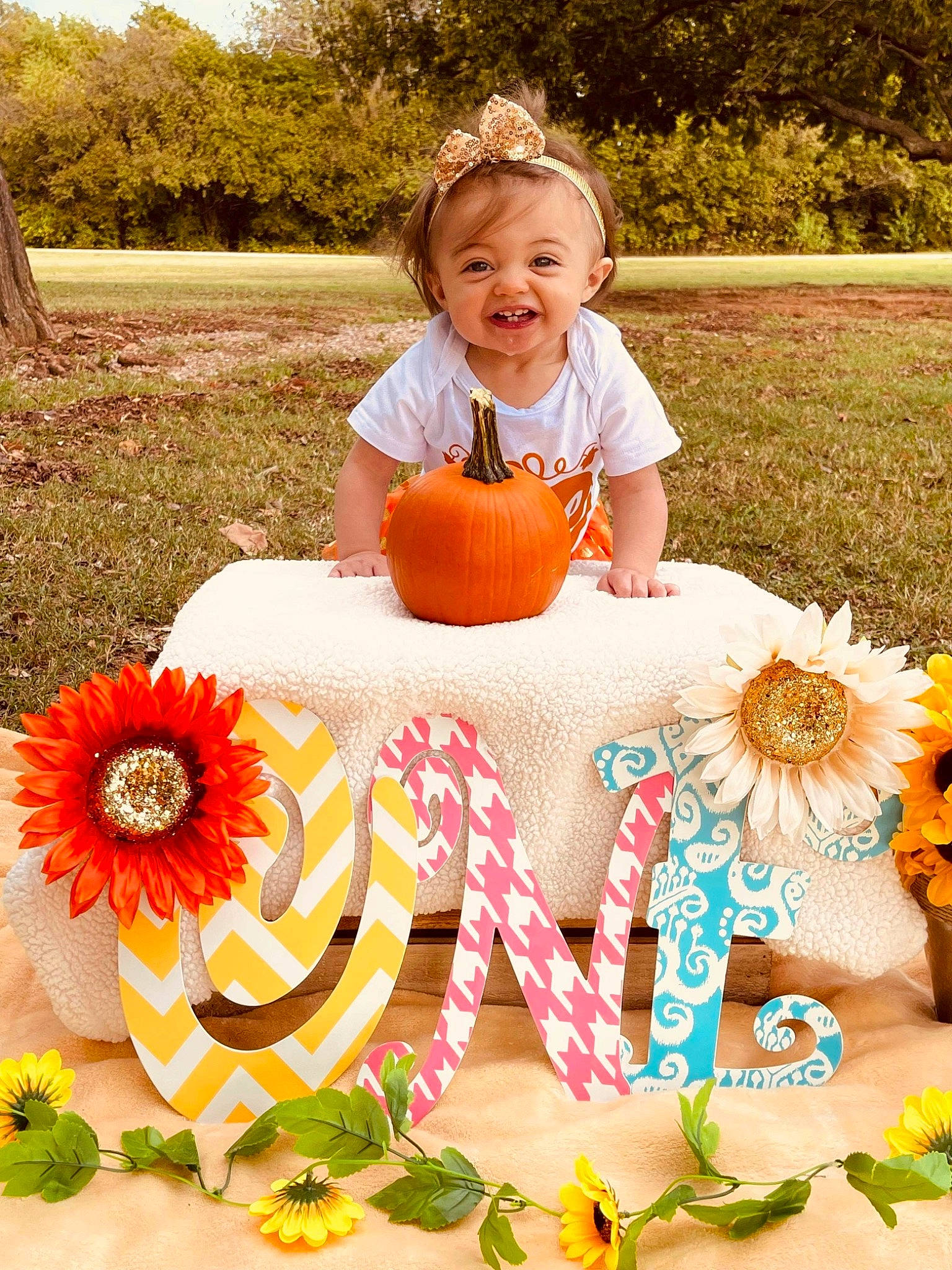 Alyssa is registered to the contest to win money with this photo: baby_toddler_clothing, botany, dress, facial_expression, flower, font, grass, happy, leisure, nature, orange, people_in_nature, person, petal, photograph, plant, smile, summer, toddler, tree