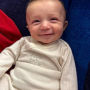 Jeremy joined the competition — help win amazing prizes! baby, blanket, blue, child, closeup, clothing, cozy, cute, face, happy, indoor, infant, person, portrait, red, sitting, smile, soft_lighting, white_outfit, young