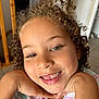 Jasmine Keira participe au concours pour gagner de l'argent avec cette photo : child, smiling, curly_hair, face, hands, indoor, happy, person, cute, portrait, gap_tooth, skin, eyebrows, eyes, mouth, cheeks, clothing, striped_shirt, earrings, playful