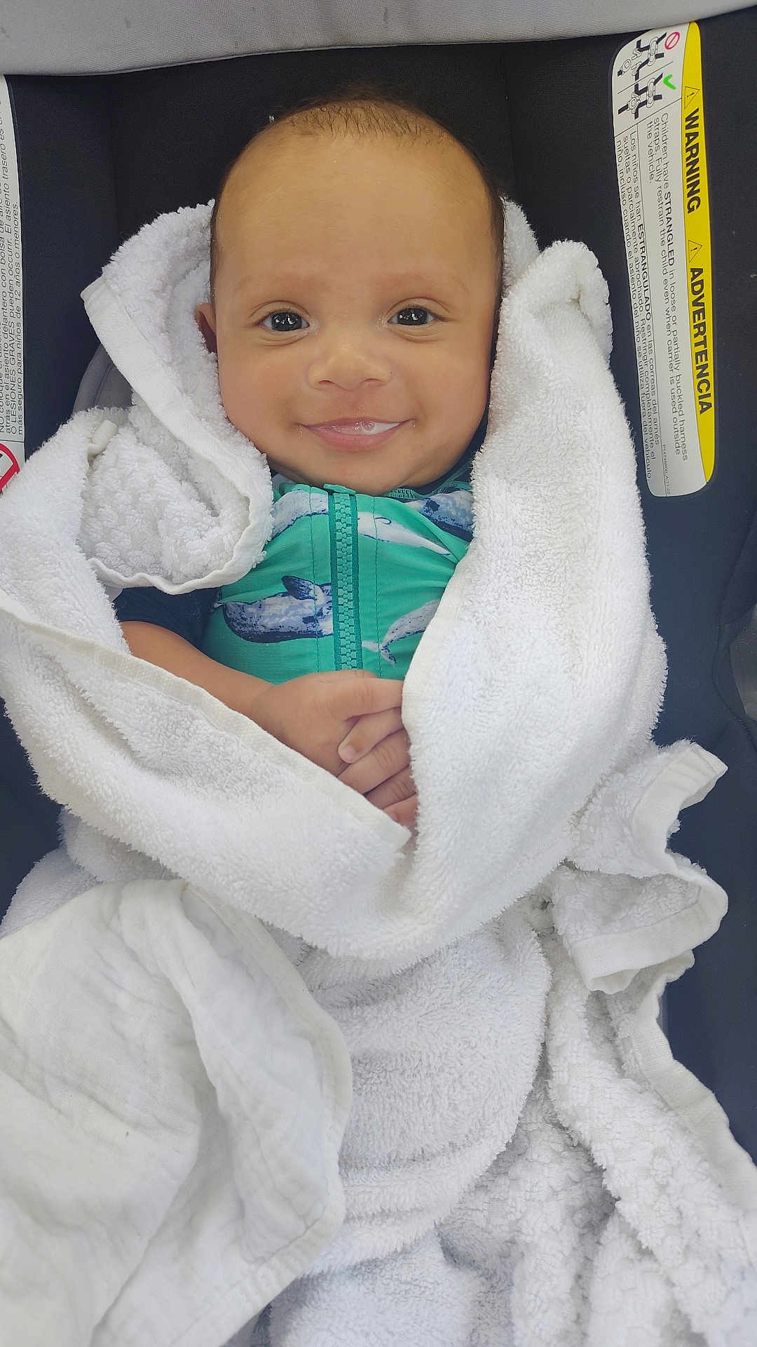 Luciano joined the competition — help win amazing prizes! baby, smiling, towel, white, car_seat, green_outfit, whale_print, infant, wrapped, cozy, cute, child, portrait, face, hands, happy, indoors, seat, warning_label, closeup