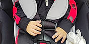 Luciano is registered to the contest to win money with this photo: baby, car_seat, child, infant, smiling, black_clothing, red_clothing, socks, blanket, safety_harness, seat_belt, cute, happy, portrait, indoor, close_up, person, young_child, baby_clothes, comfort